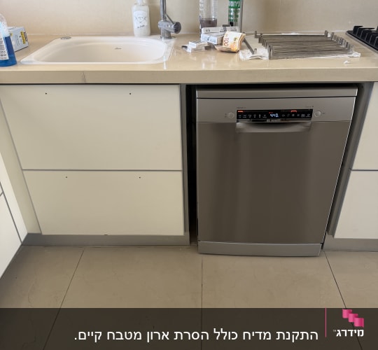 מדיח כלים מותקן לצד כיור מטבח ומשטח עבודה